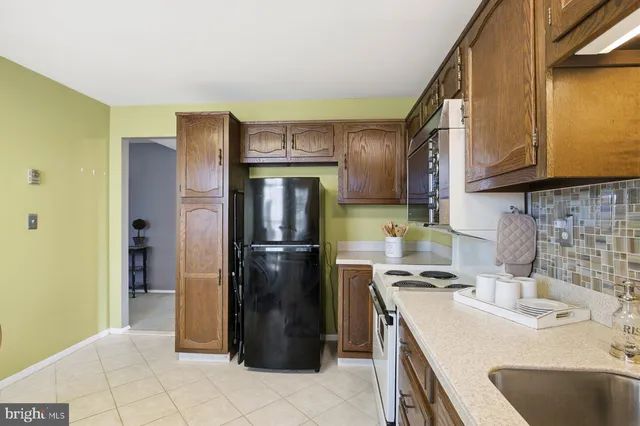 a kitchen with stainless steel appliances granite countertop a refrigerator a sink and a stove