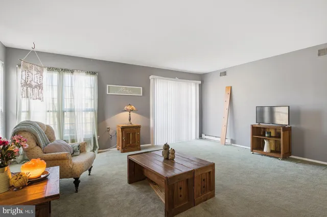 a living room with furniture a table and a flat screen tv