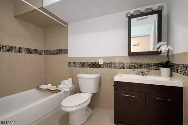 a bathroom with a granite countertop toilet a sink and a mirror