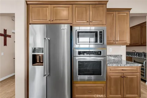 a kitchen with stainless steel appliances granite countertop a refrigerator and a stove top oven