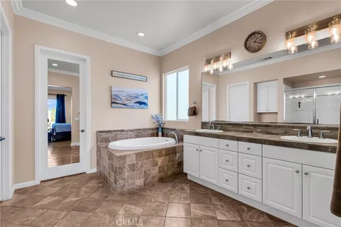 a spacious bathroom with a granite countertop sink a mirror and a bathtub