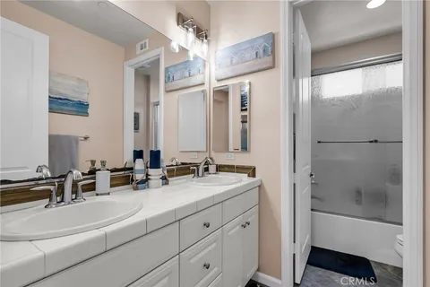 a bathroom with double vanity and a mirror