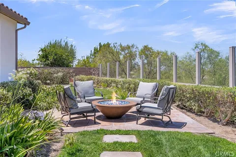 a view of a patio with chair and tables back yard of the house