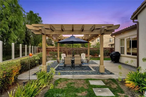 a patio with table and chairs and potted plants