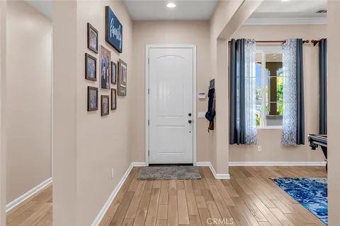 a view of a hallway with wooden floor and a rug