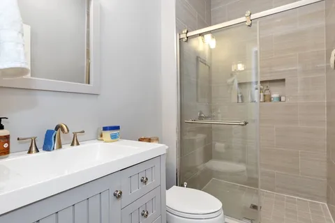 a bathroom with a sink a toilet and shower