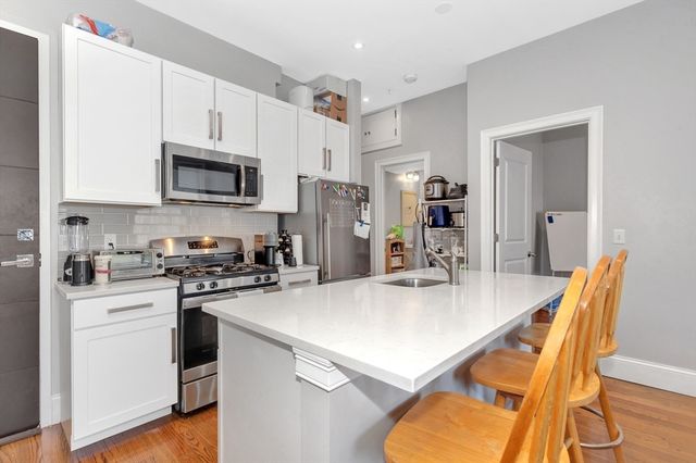 a kitchen with stainless steel appliances a stove sink microwave refrigerator and cabinets