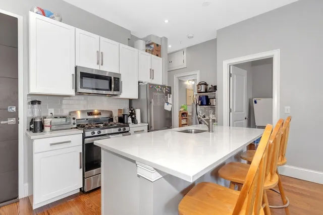 a kitchen with stainless steel appliances a stove sink microwave refrigerator and cabinets