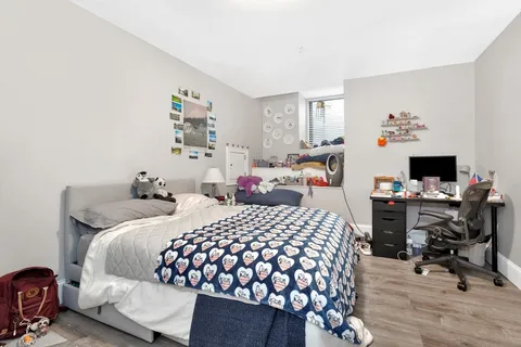 a bedroom with a bed and wooden floor