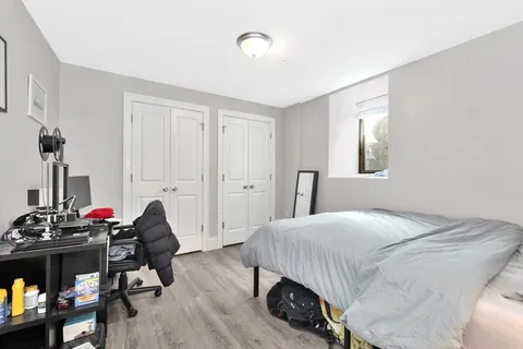 a bedroom with a bed and a wooden floor