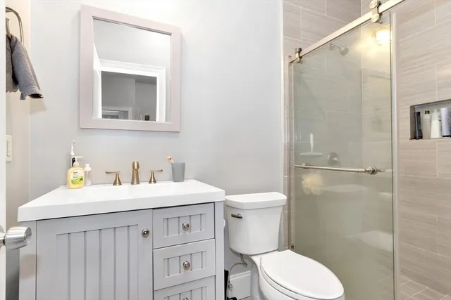 a bathroom with a sink a toilet and shower