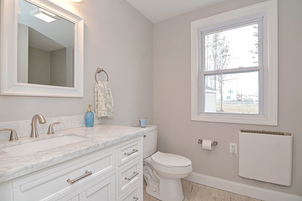 14 Allen Road Norwood, MA 02062 - Photo 15 of 36 a bathroom with a granite countertop toilet a sink a mirror and a window