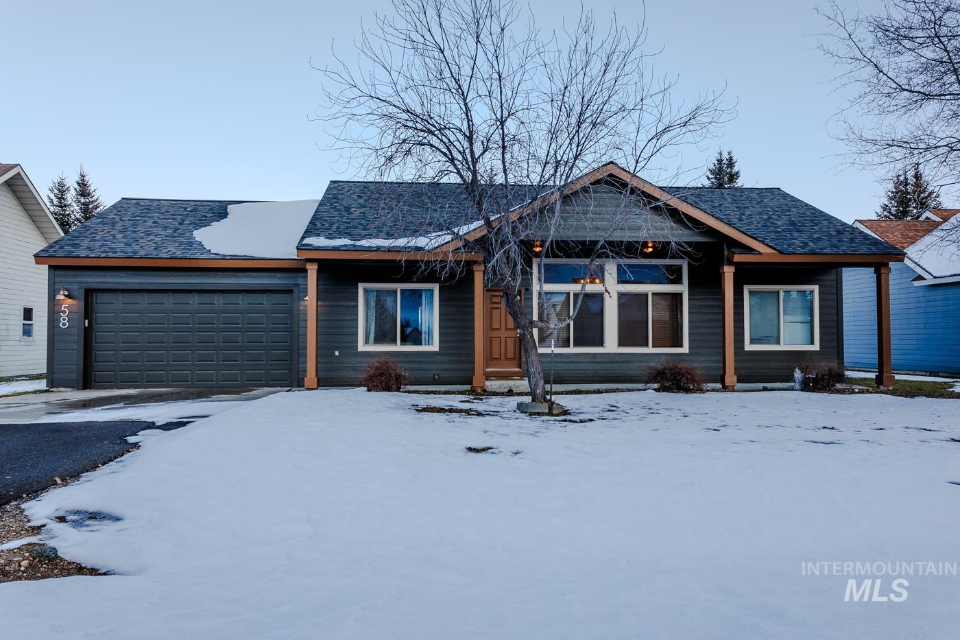 View of front facade featuring an attached garage, asphalt driveway, and roof with shingles