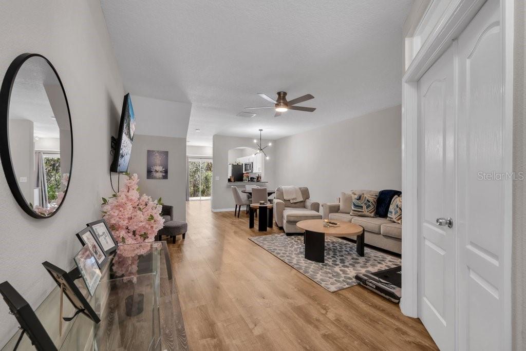 15855 Fishhawk View Drive Lithia, FL 33547 - Photo 2 of 31 a living room with furniture a mirror and wooden floor