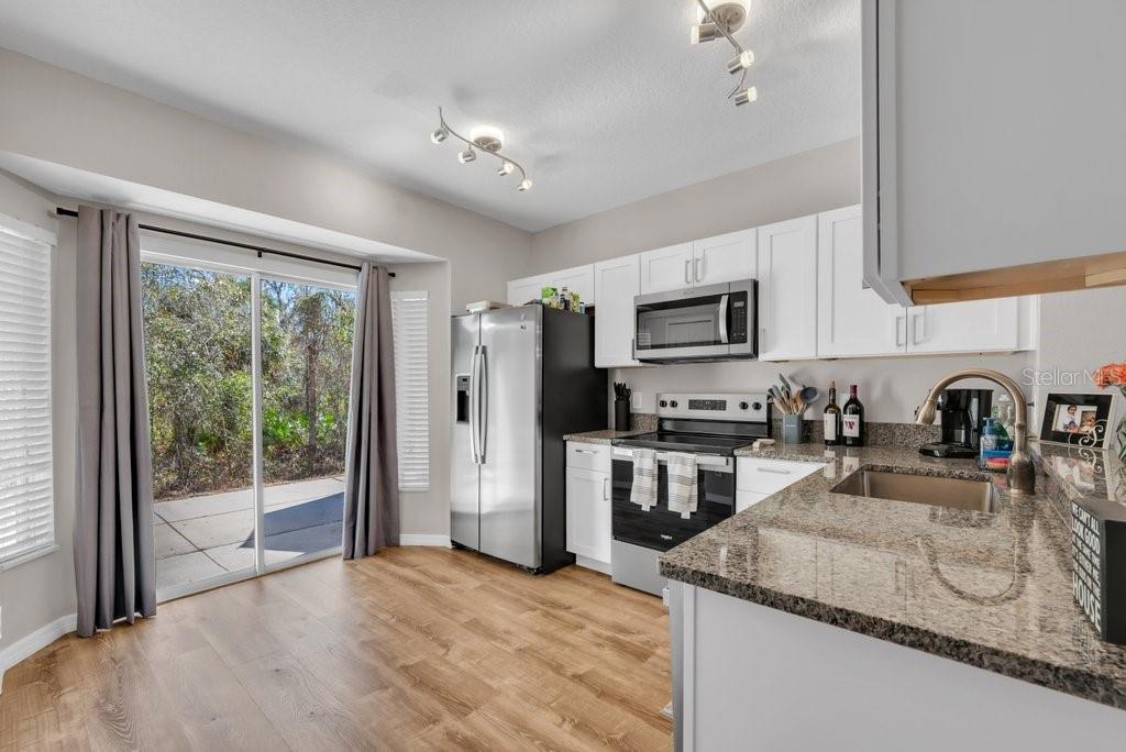 15855 Fishhawk View Drive Lithia, FL 33547 - Photo 9 of 31 a kitchen with stainless steel appliances granite countertop a refrigerator a stove top oven a sink and dishwasher