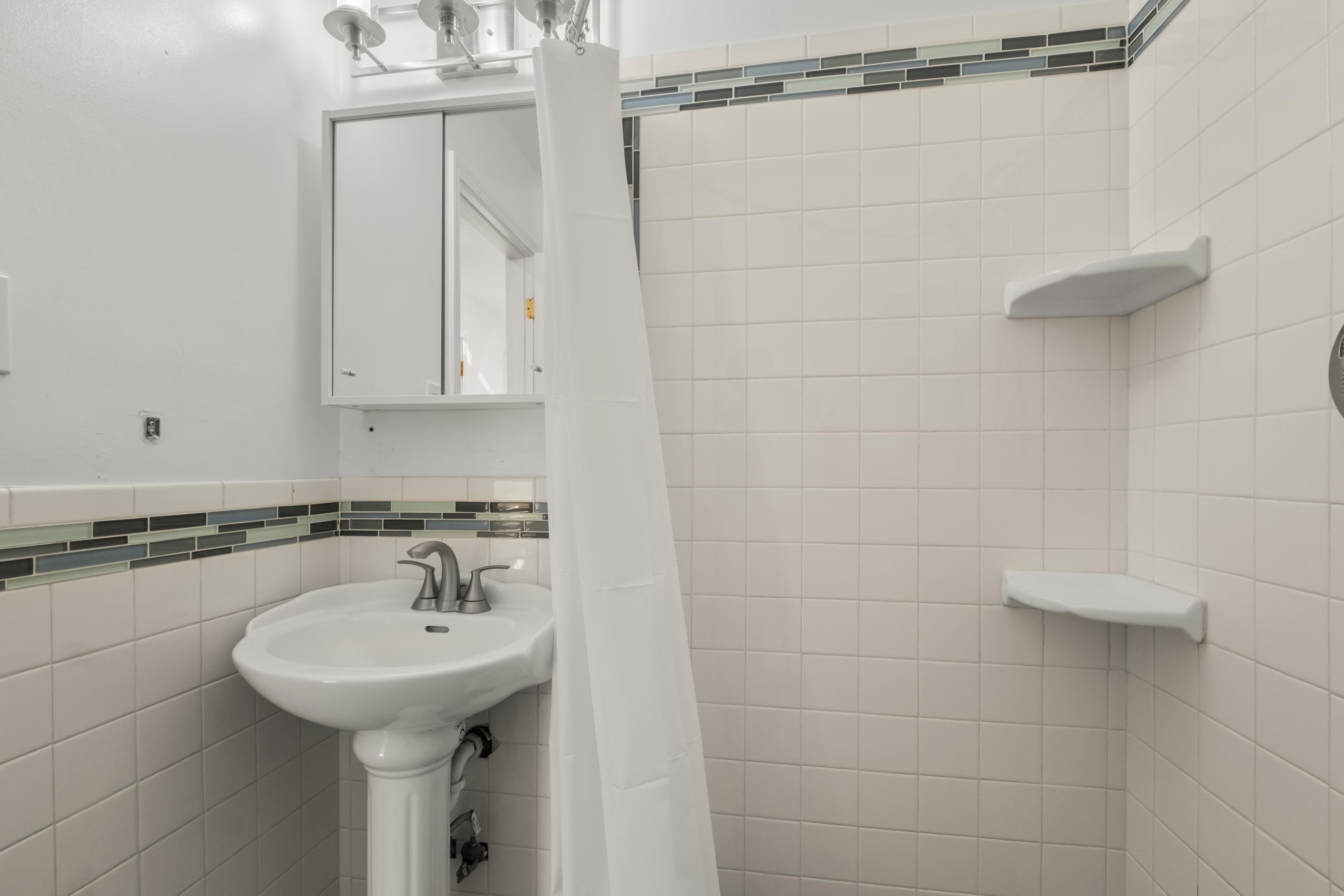 1039 Channing Way Berkeley, CA 94710 - Photo 12 of 25 Bathroom featuring curtained shower, tile walls, and a wainscoted wall