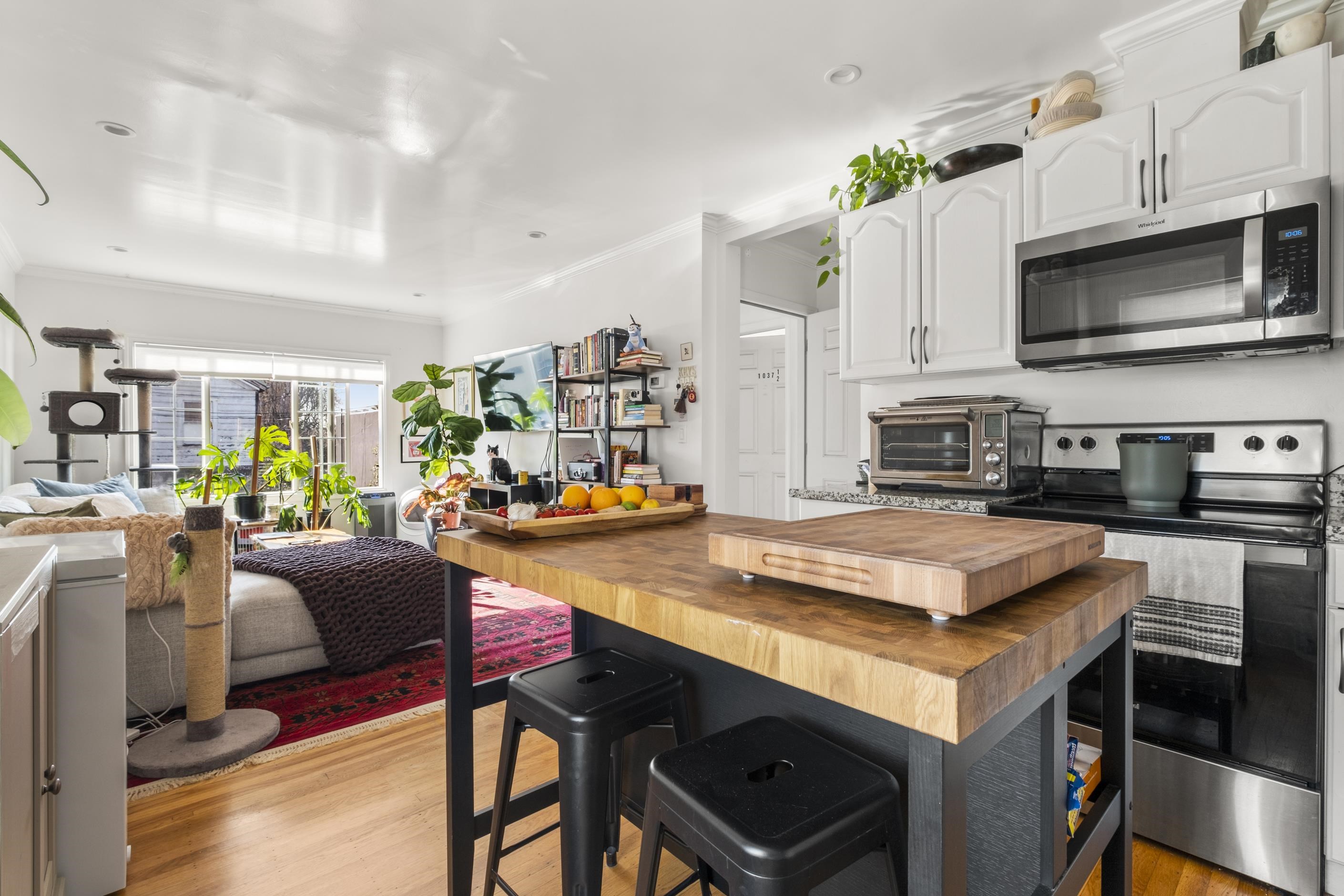 1039 Channing Way Berkeley, CA 94710 - Photo 25 of 25 Kitchen featuring wooden counters, stainless steel appliances, open floor plan, a breakfast bar area, and ornamental molding