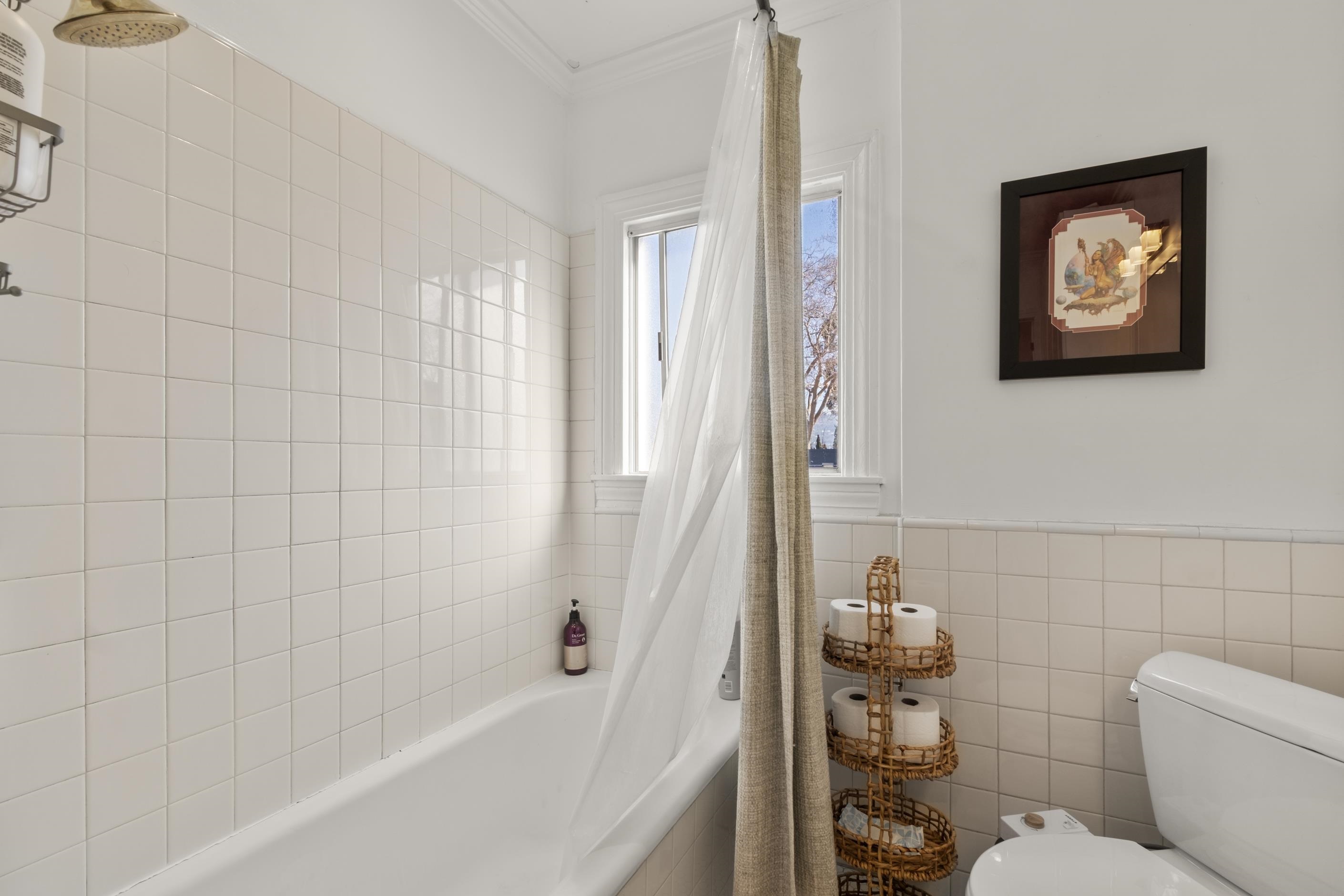 1039 Channing Way Berkeley, CA 94710 - Photo 18 of 25 Full bath featuring tile walls, tiled shower / bath combo, ornamental molding, and wainscoting