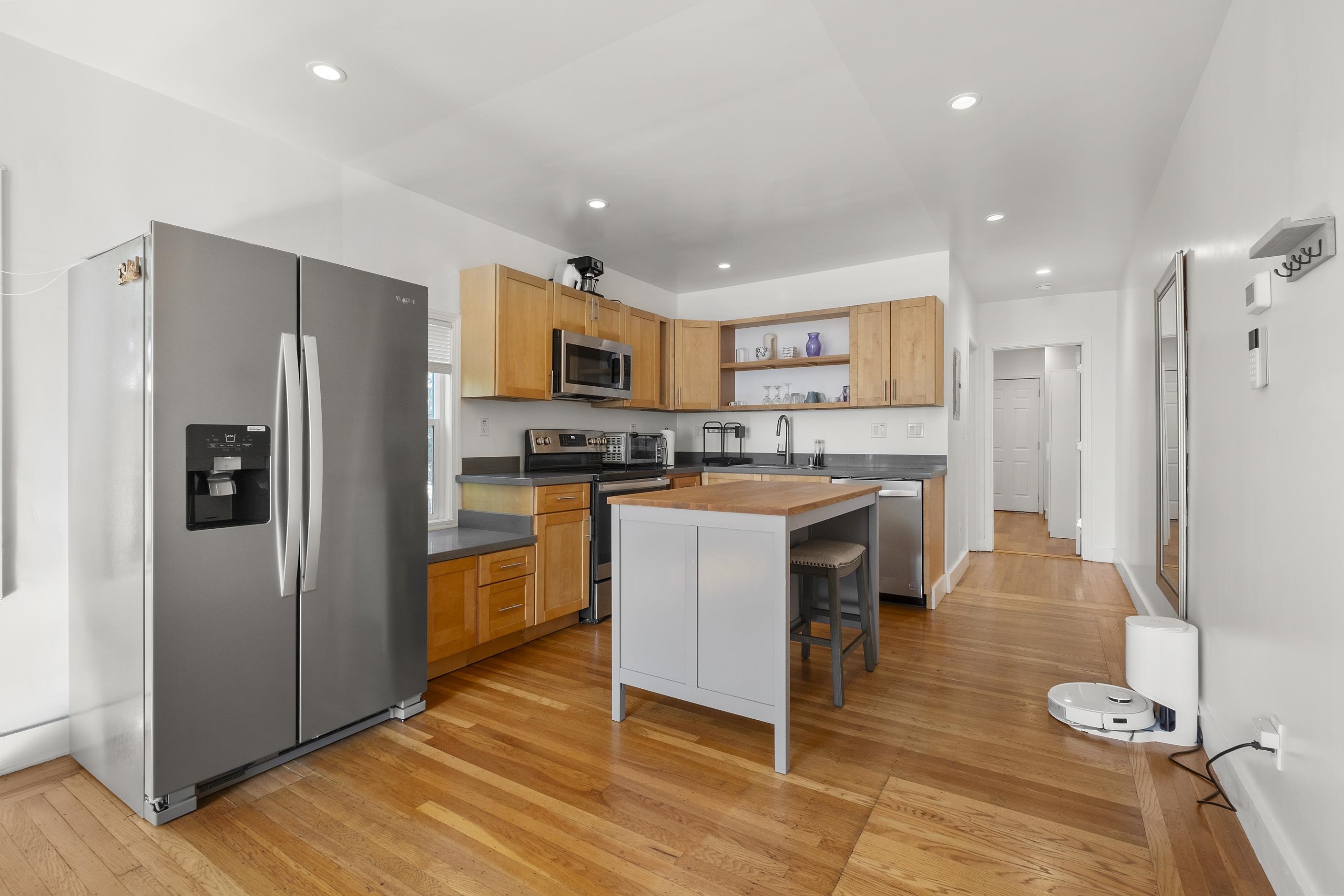 1039 Channing Way Berkeley, CA 94710 - Photo 21 of 25 Kitchen with stainless steel appliances, a kitchen breakfast bar, open shelves, a center island, and light wood-style floors