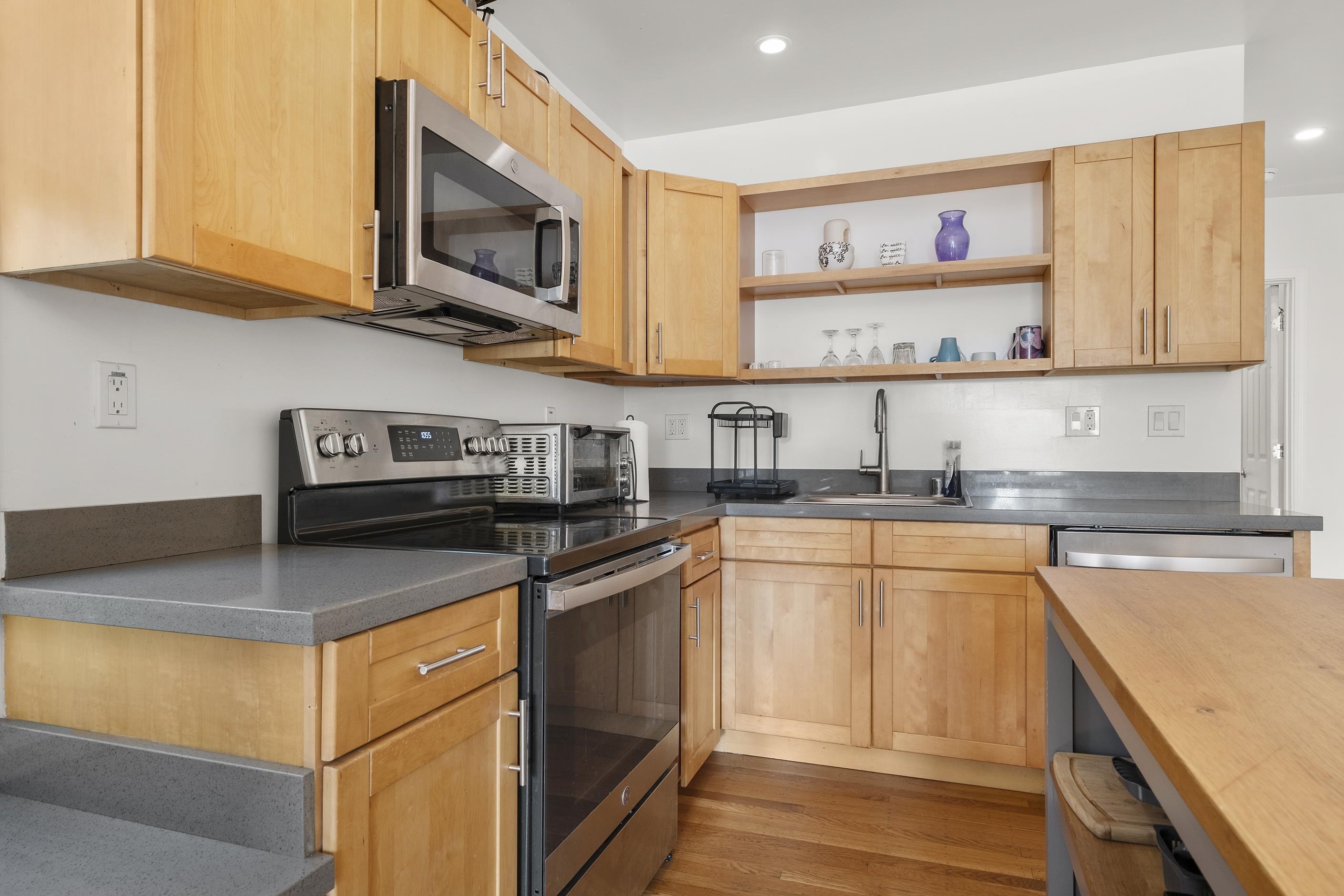 1039 Channing Way Berkeley, CA 94710 - Photo 22 of 25 Kitchen with stainless steel appliances, open shelves, wooden counters, light wood finished floors, and recessed lighting
