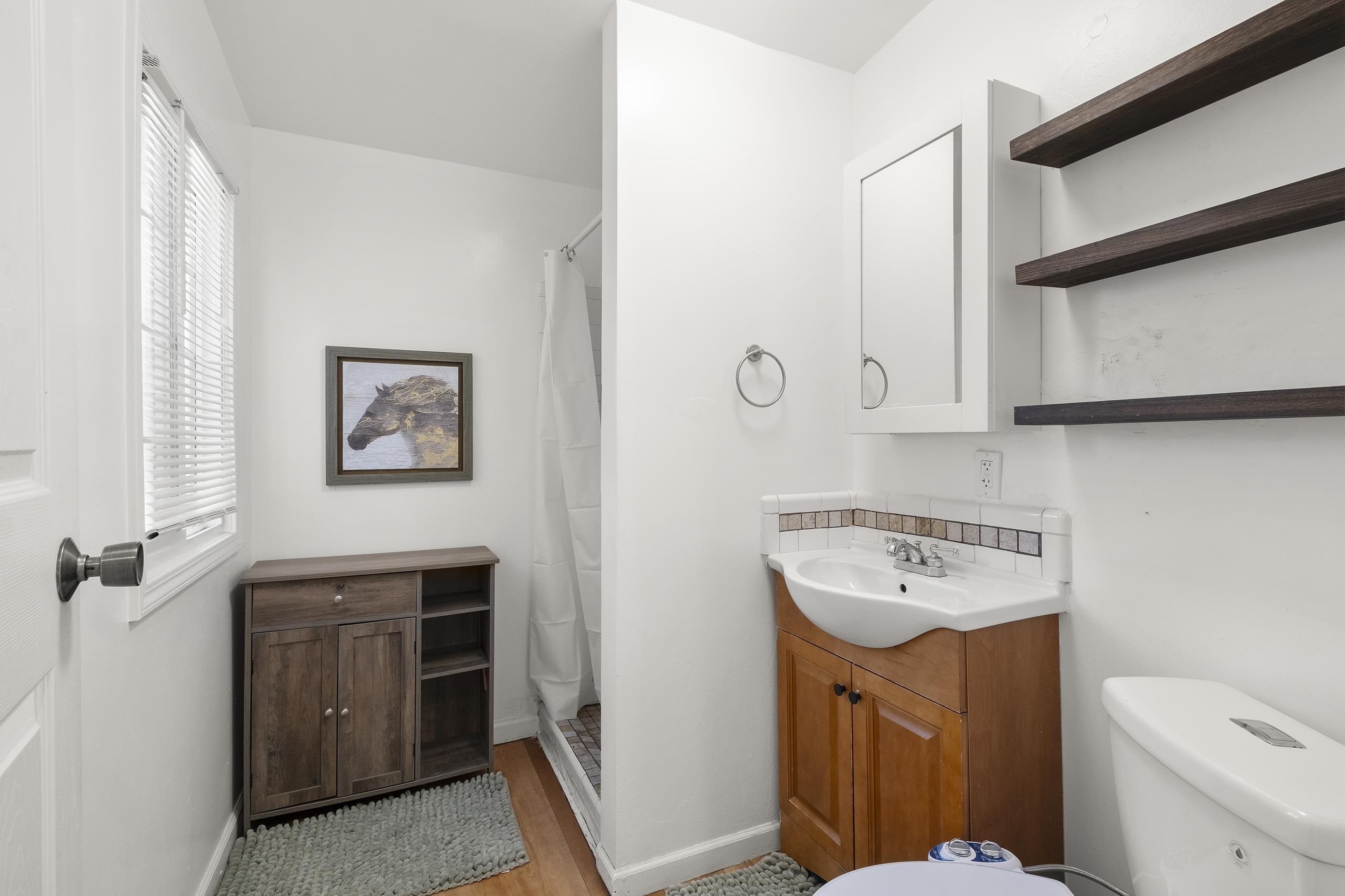 1039 Channing Way Berkeley, CA 94710 - Photo 7 of 25 Bathroom featuring vanity, a shower with shower curtain, tasteful backsplash, and light wood-style floors