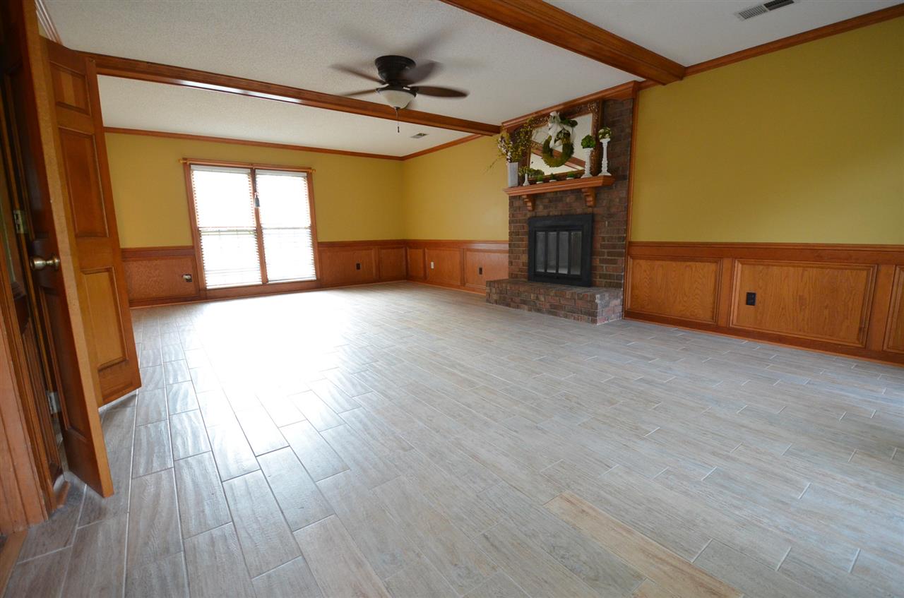 4010 Bartlett Country Road Bartlett, TN 38135 - Photo 7 of 25 The living room has a wood burning fireplace and hard surface flooring.