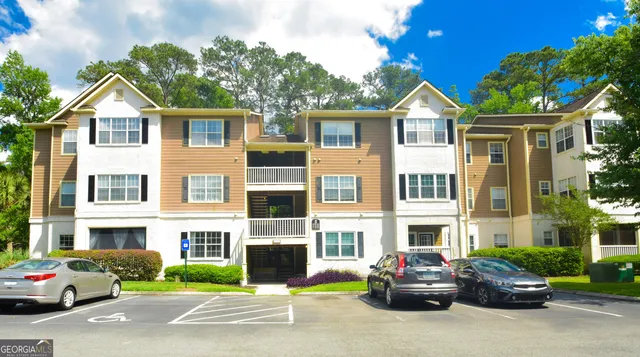 a view of multiple houses with cars parked on the street