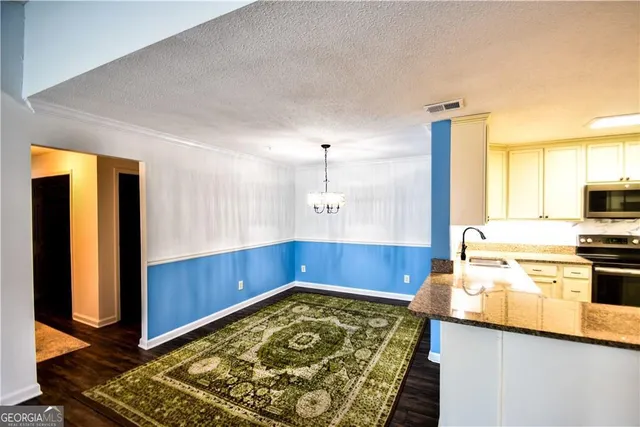 a kitchen with granite countertop a refrigerator cabinets and wooden floor