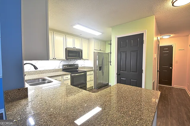 a kitchen with a sink stove and microwave