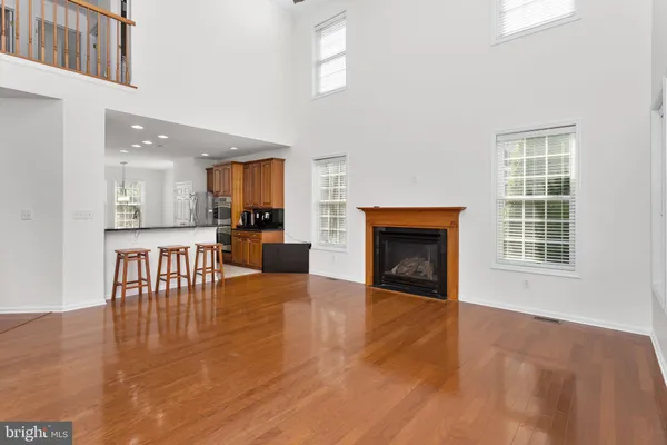 an empty room with wooden floor and a fireplace