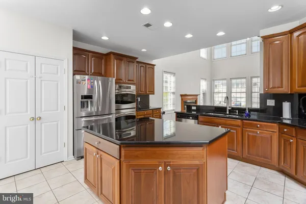 a kitchen with stainless steel appliances granite countertop a refrigerator and a sink