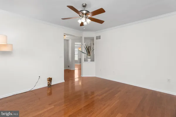 a view of an empty room with window and a ceiling fan