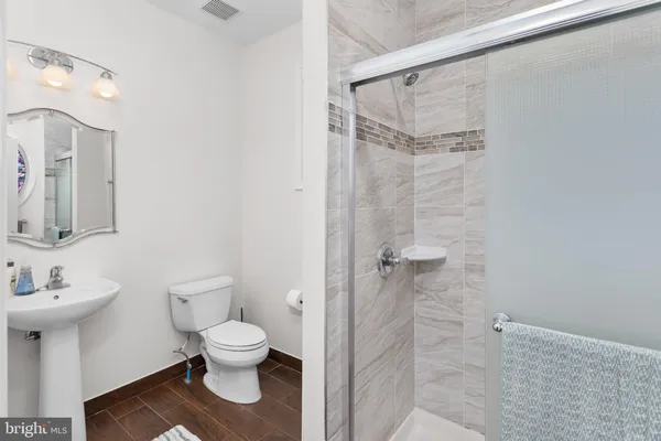 a bathroom with a toilet sink a shower and a mirror