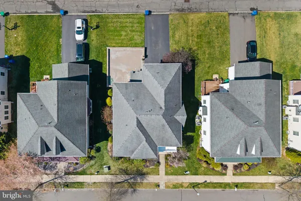 an aerial view of a house with a yard and large tree