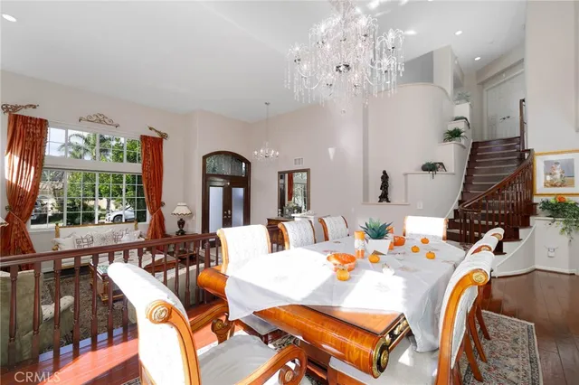 a view of a dining room with furniture a chandelier and wooden floor