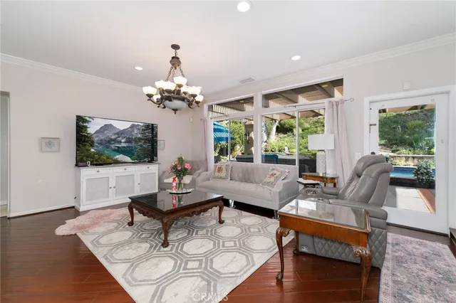 a living room with furniture a chandelier and a flat screen tv