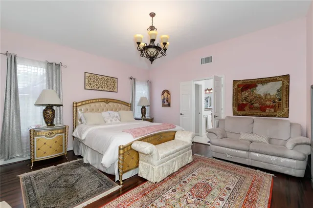 a bedroom with a bed mirror and couch