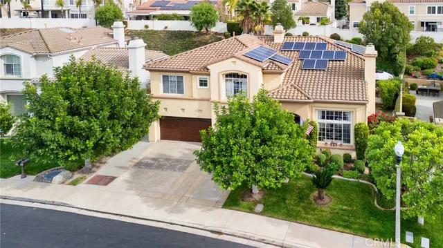 a front view of a house with a yard and trees
