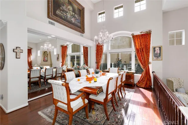 a dining room with furniture a chandelier and wooden floor