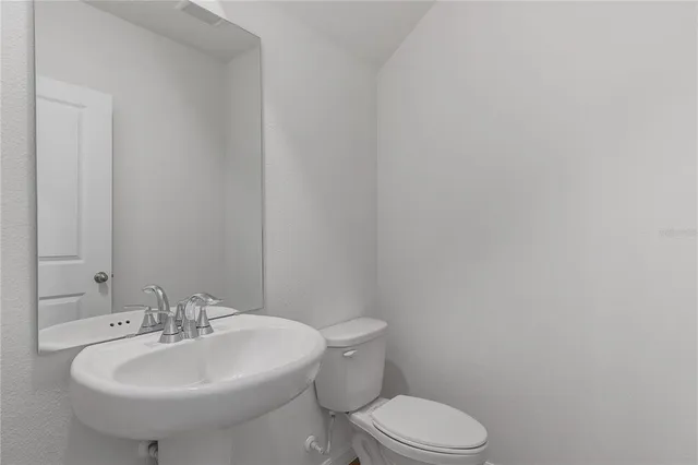 a bathroom with a sink a toilet and mirror