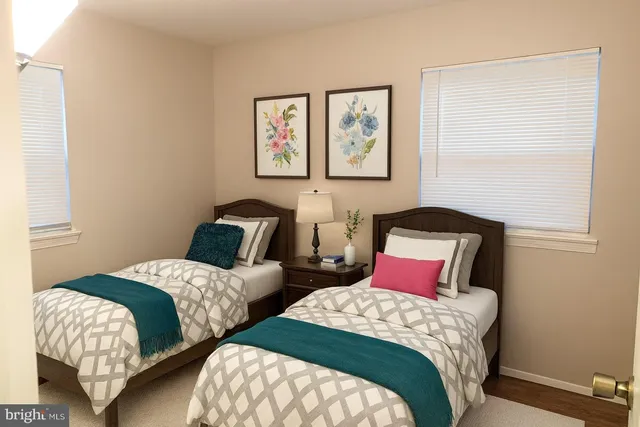 a bedroom with two beds and painting on the wall