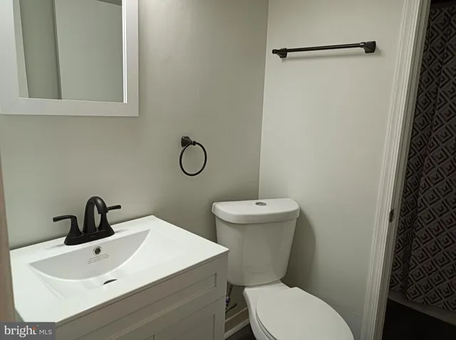 a bathroom with a toilet sink and mirror