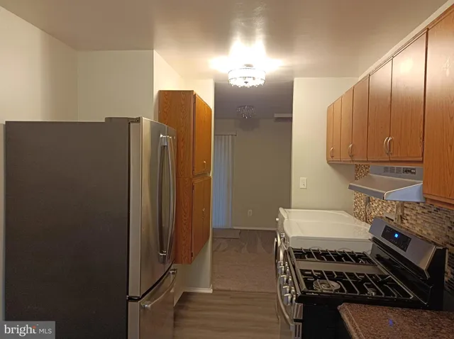 a kitchen with stainless steel appliances granite countertop a refrigerator and a stove