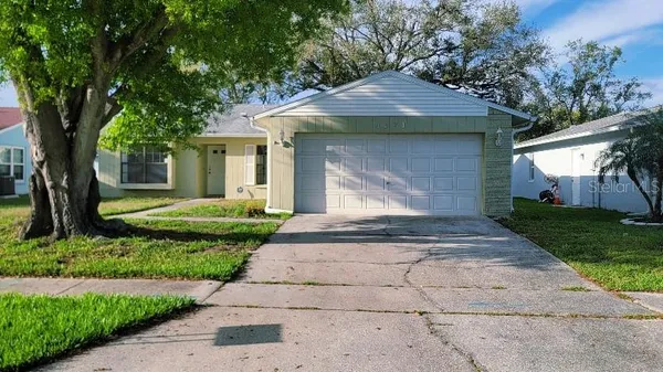 a front view of a house with a yard and trees