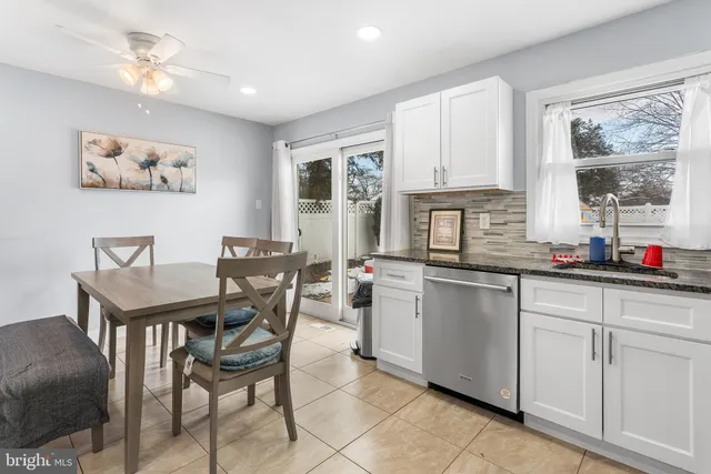 a kitchen with stainless steel appliances white cabinets and a refrigerator