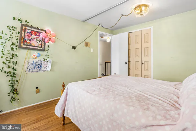 a bedroom with a bed and a dresser next to a window
