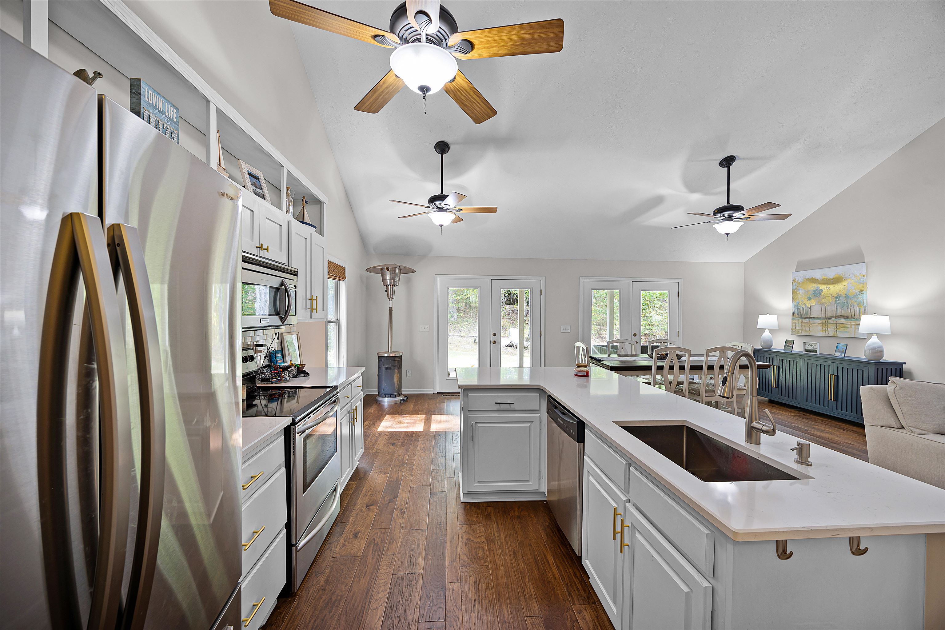 100 Masters Court Counce, TN 38326 - Photo 18 of 28 a kitchen with stainless steel appliances a stove a sink dishwasher a refrigerator and a dining table with wooden floor