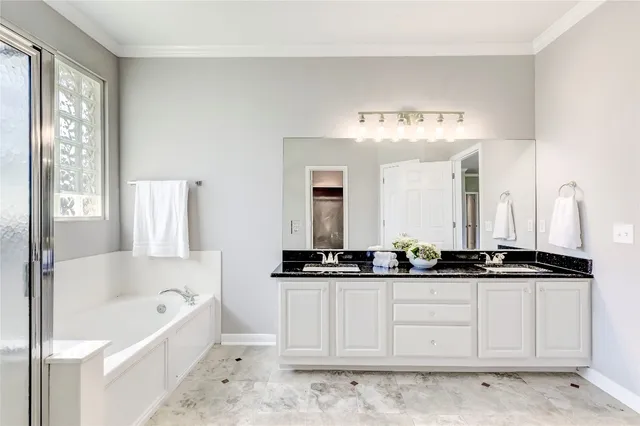 a spacious bathroom with a granite countertop sink a mirror and a bathtub