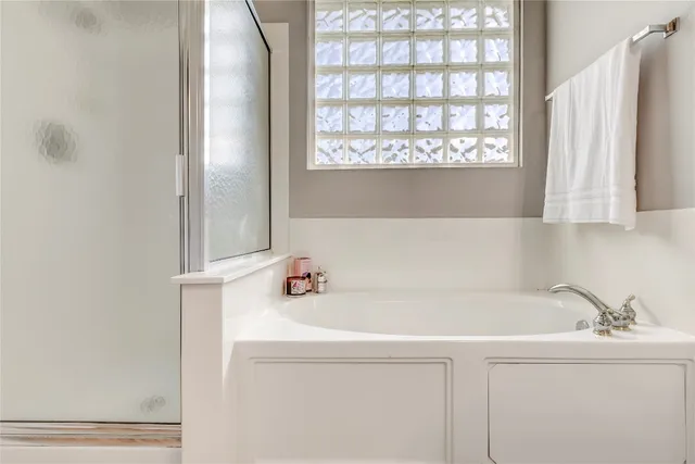 a bathroom with a bathtub a double vanity sink and mirror