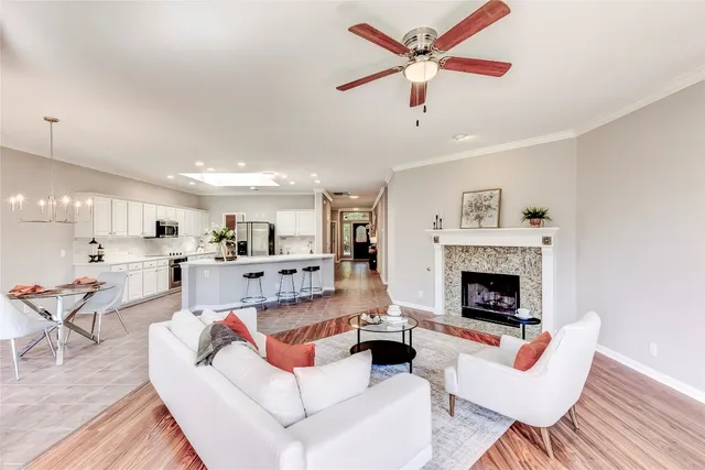a living room with furniture a fireplace and kitchen view